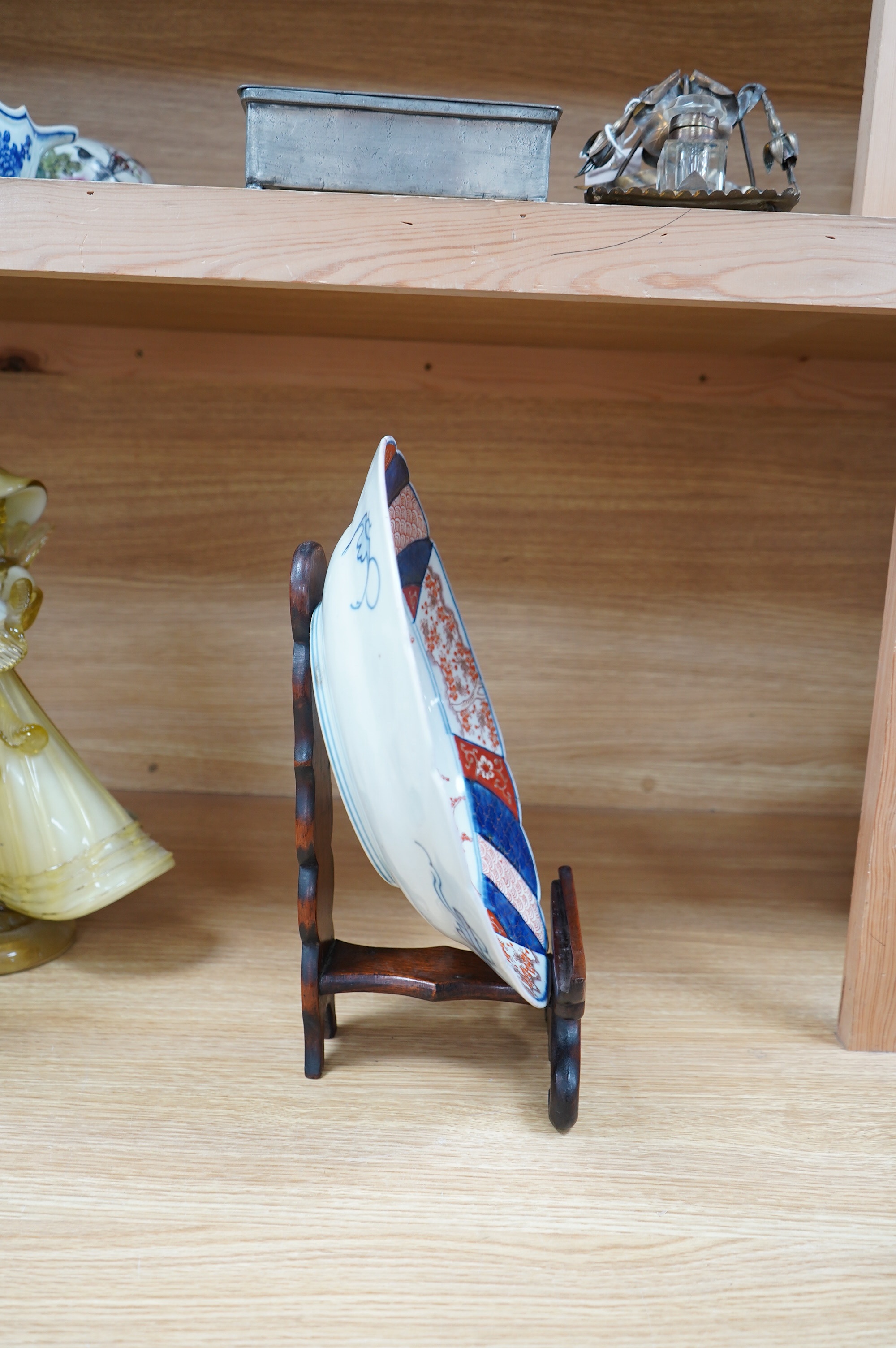 A Japanese Imari dish, circa 1900, on carved wooden stand, 31cm diameter. Condition - fine crack top right base of dish